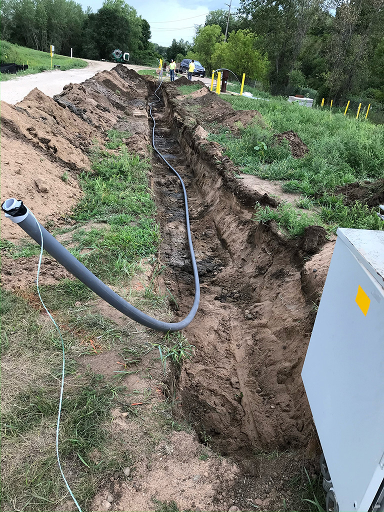 Laying conduit in trench